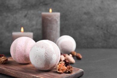 Bath bombs, candles and dry flowers on black table, space for text