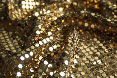 Photo of Texture of beautiful golden fabric with paillettes as background, closeup