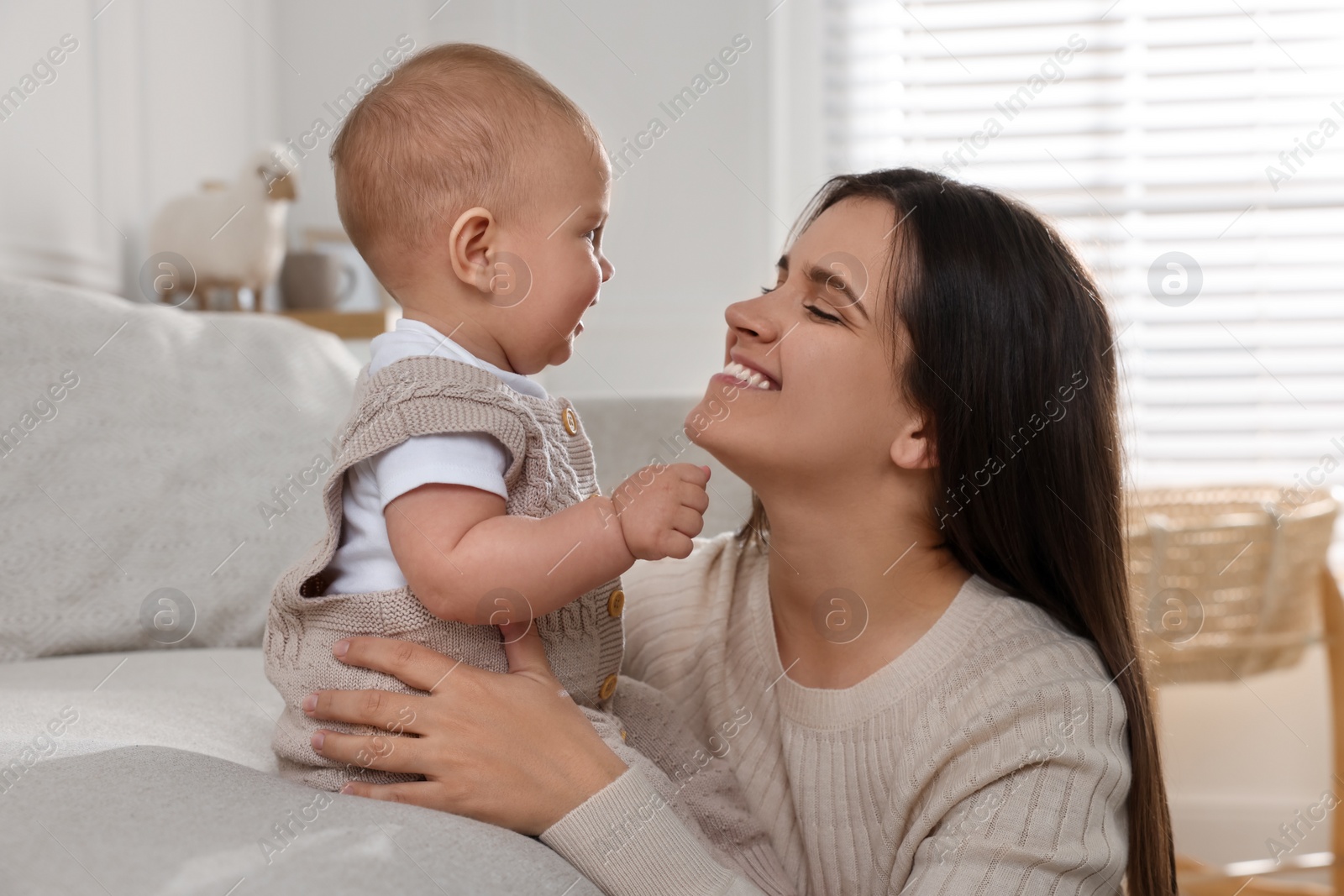 Photo of Happy young mother with her baby in living room