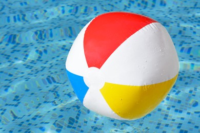 Photo of Inflatable beach ball floating in swimming pool, closeup