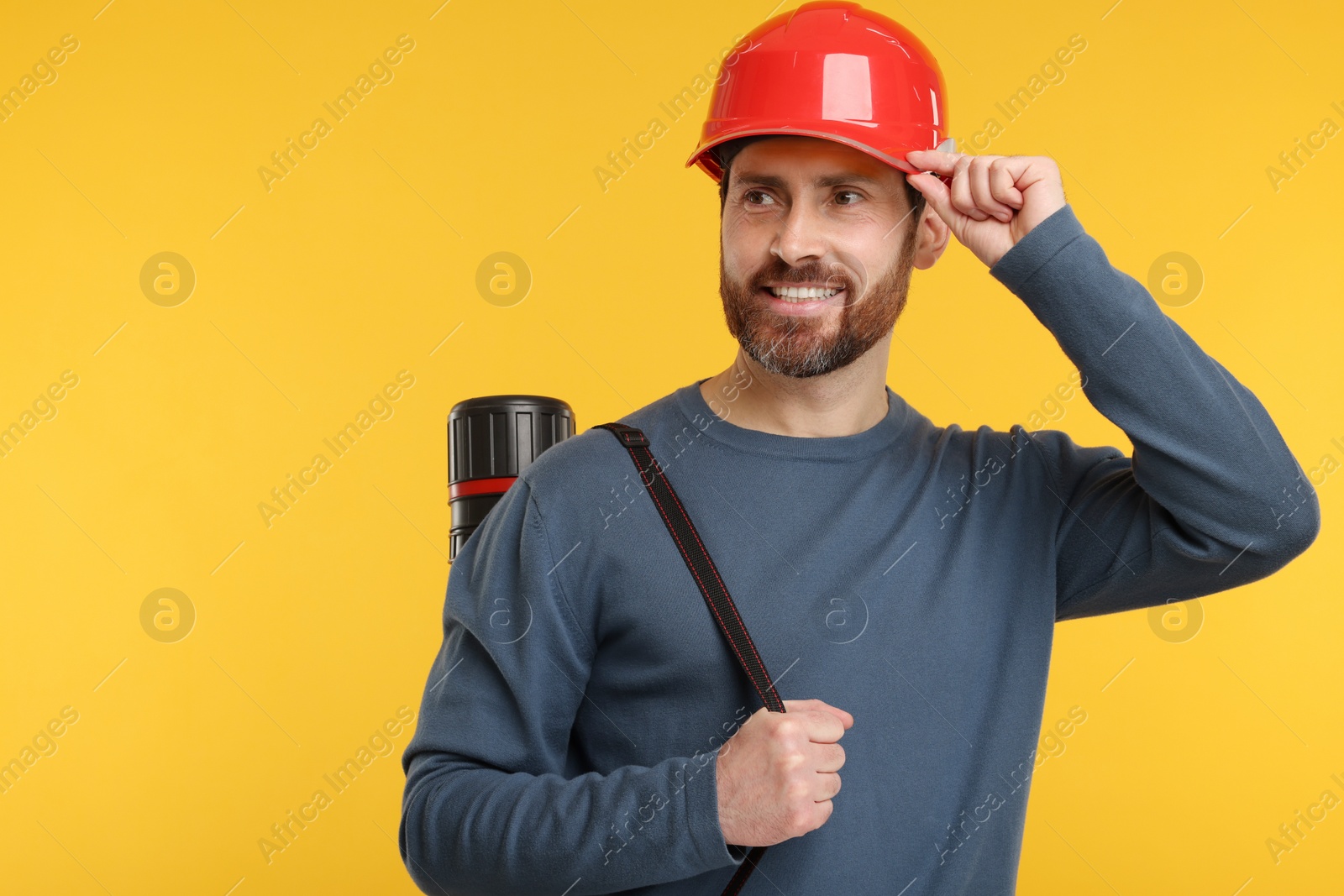 Photo of Architect in hard hat with drawing tube on orange background, space for text