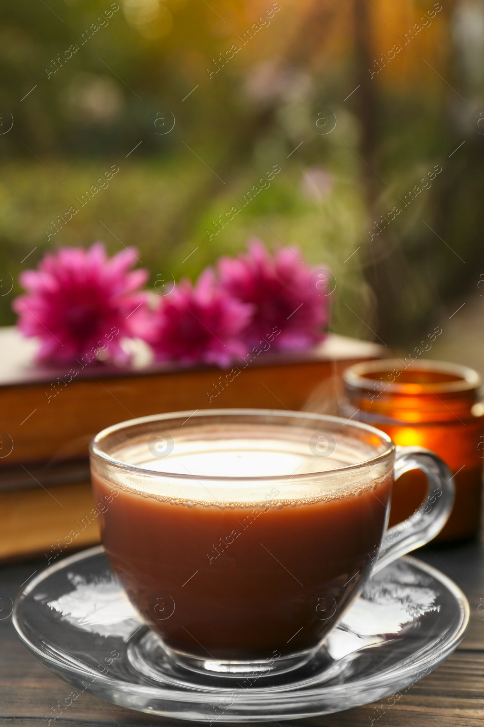 Photo of Glass cup with coffee on wooden table. Morning ritual