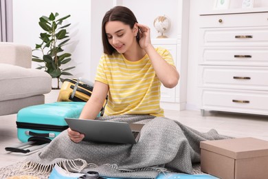 Travel blogger using laptop for planning trip at home