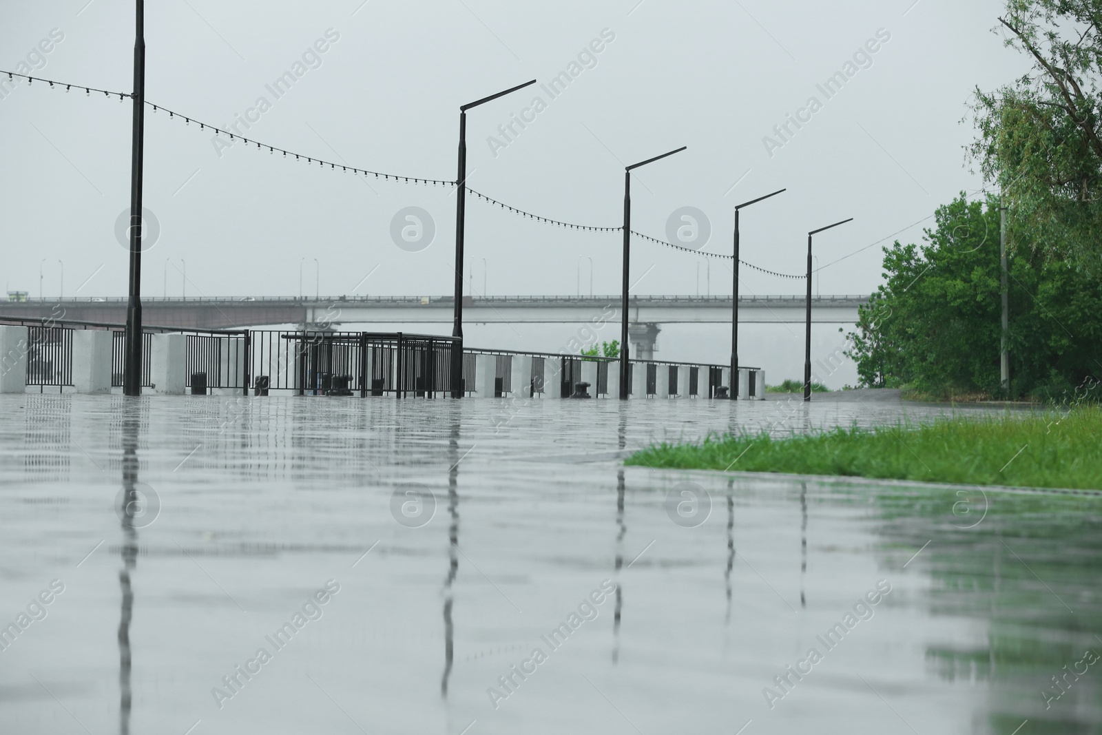 Photo of Empty city embankment under heavy rain on spring day