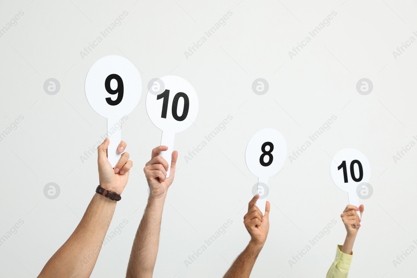 Photo of Panel of judges holding different score signs on white background, closeup