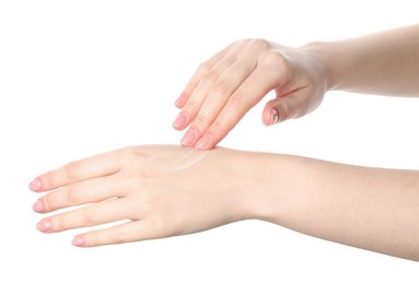 Woman applying cream on her hand against white background, closeup