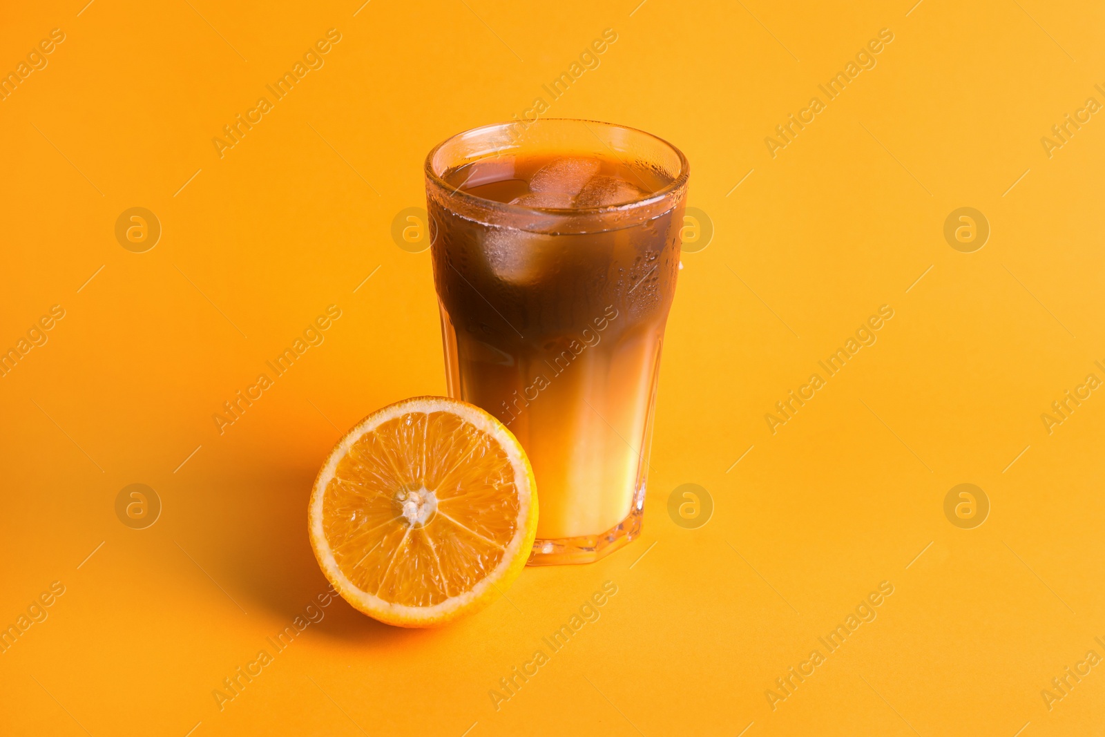 Photo of Tasty refreshing drink with coffee and orange juice on bright color background