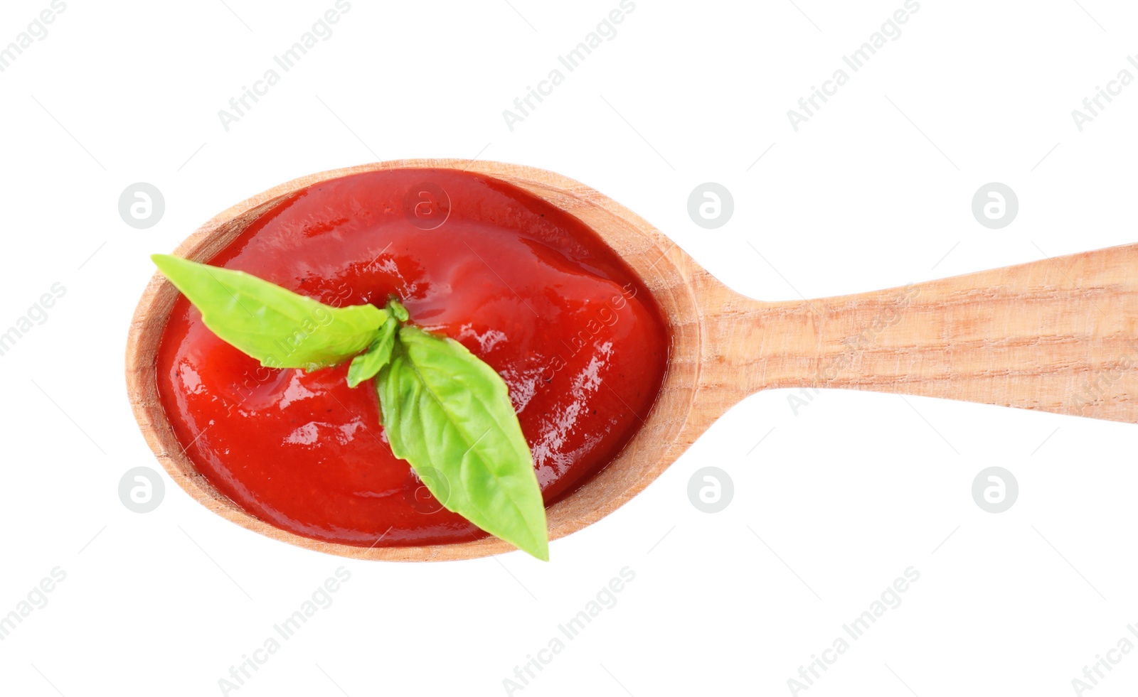 Photo of Tasty tomato sauce in wooden spoon isolated on white, top view