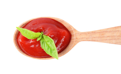 Photo of Tasty tomato sauce in wooden spoon isolated on white, top view