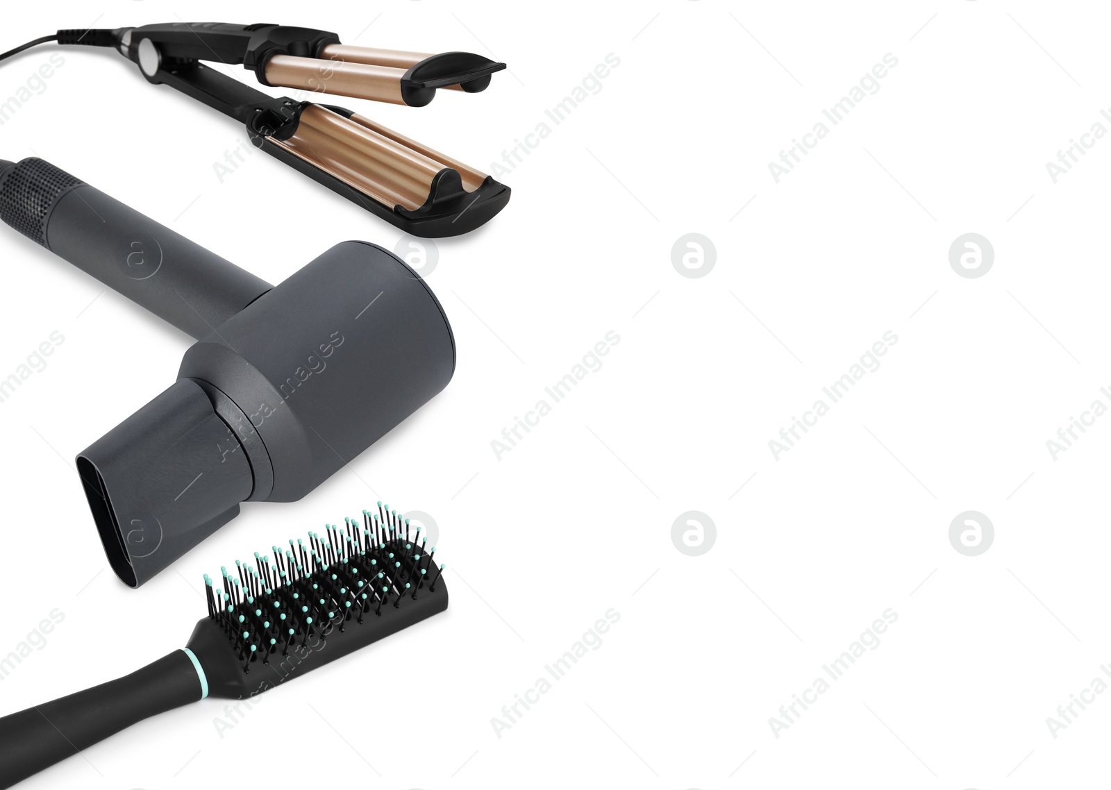 Image of Hair dryer, triple curling iron and brush on white background