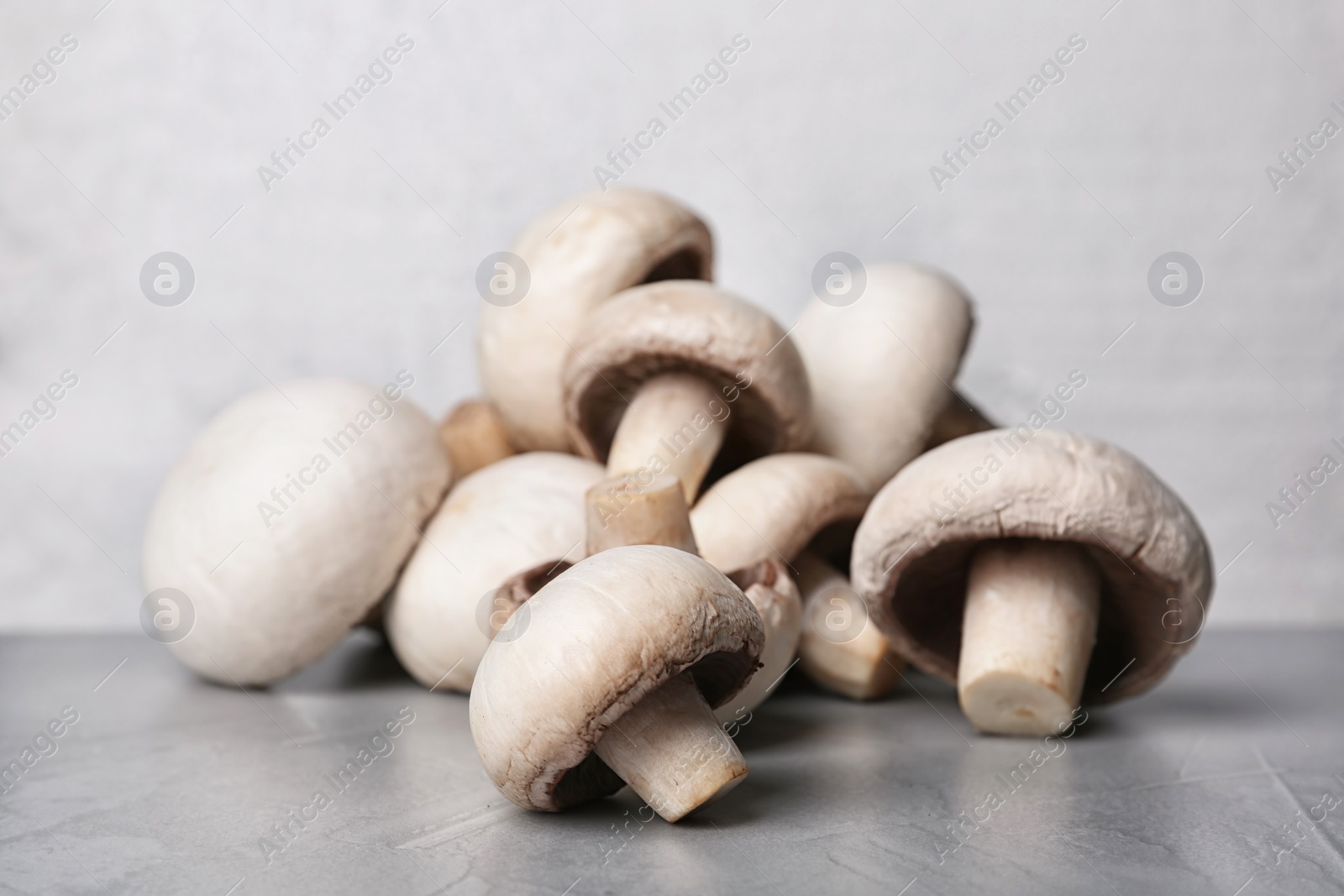 Photo of Pile of fresh champignon mushrooms on table, closeup