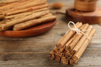 Photo of Aromatic cinnamon sticks on wooden table, space for text