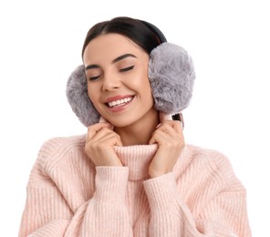 Beautiful young woman wearing earmuffs on white background