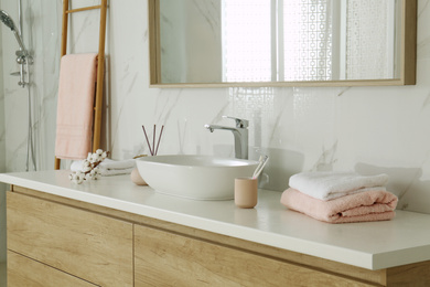 Large mirror over vessel sink in stylish bathroom interior