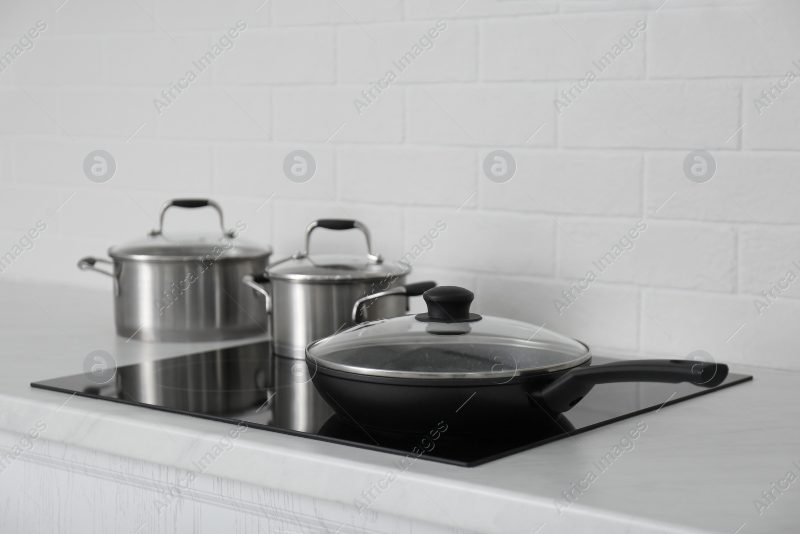 Photo of New cookware on induction stove in kitchen