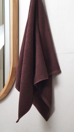 Photo of Brown soft towel hanging on grey wall in bathroom