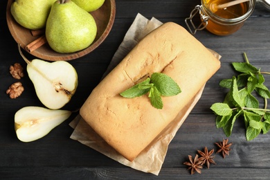 Flat lay composition with pear bread with mint on black wooden table. Homemade cake