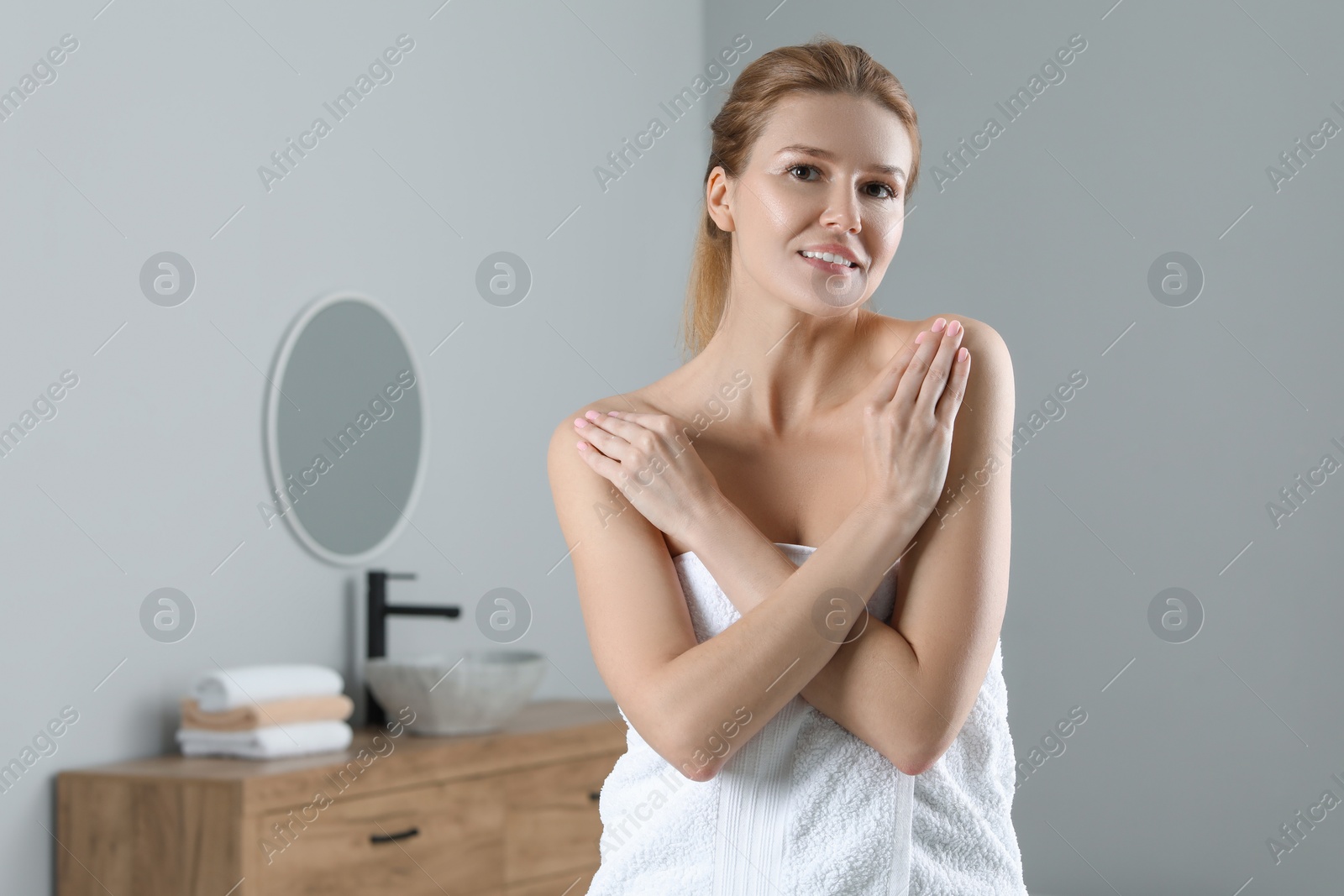 Photo of Happy woman with smooth skin in bathroom, space for text