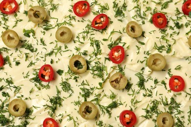 Photo of Fresh natural butter with cut olives, dill and pepper as background, top view