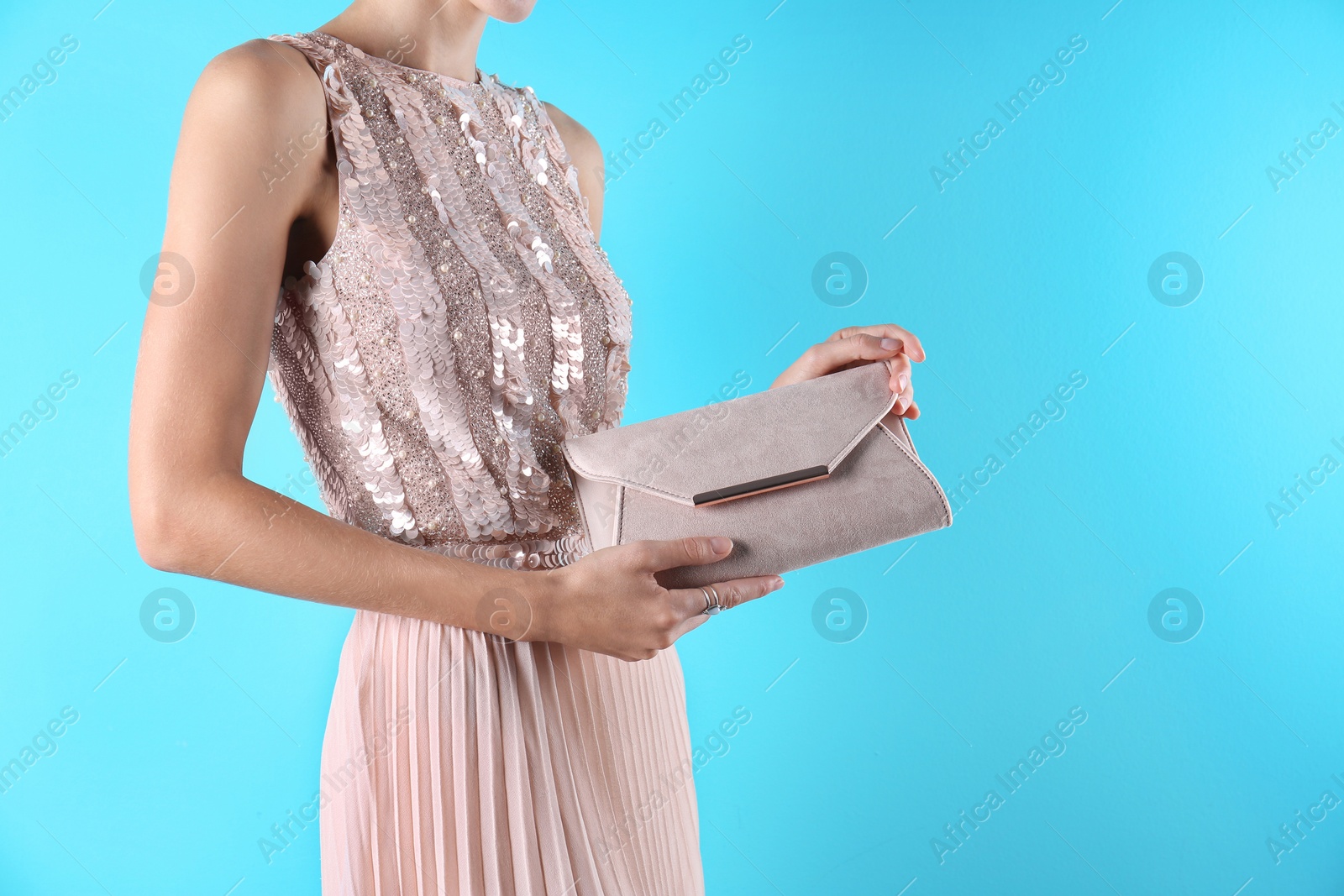 Photo of Young woman in stylish outfit with purse on color background, closeup