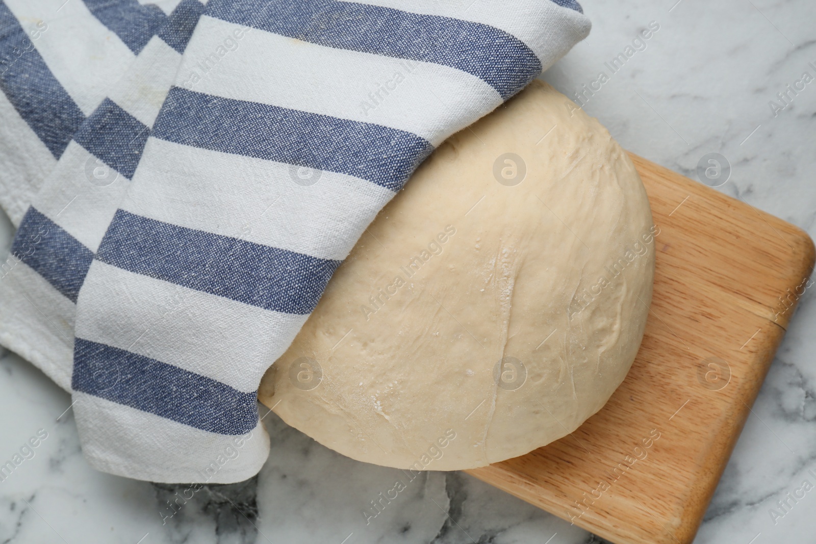 Photo of Fresh yeast dough on white marble table, top view