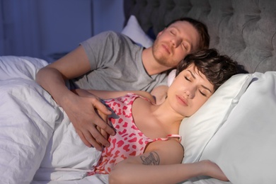 Photo of Young lovely couple sleeping in bed at home