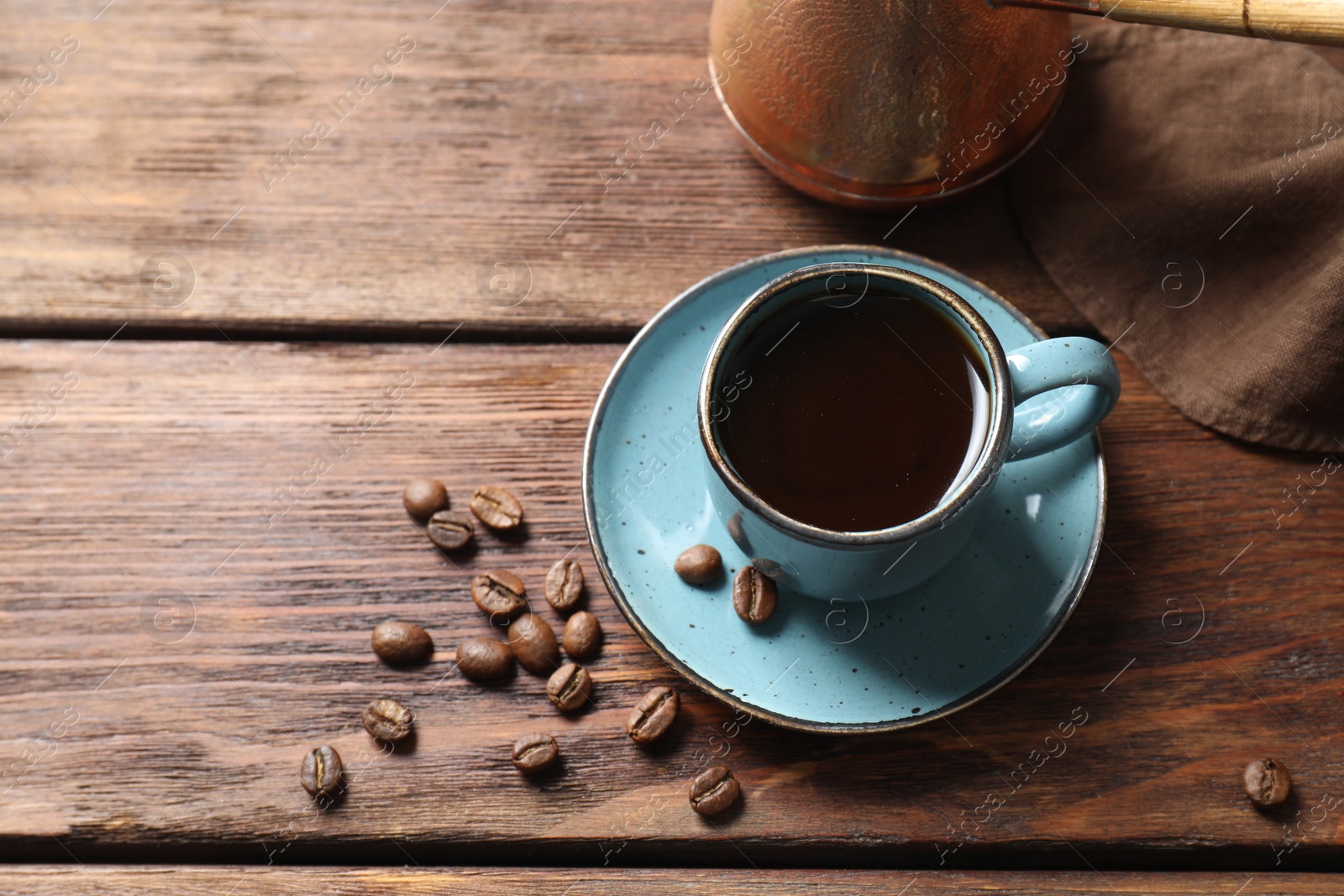 Photo of Turkish coffee. Freshly brewed beverage and beans on wooden table, above view. Space for text