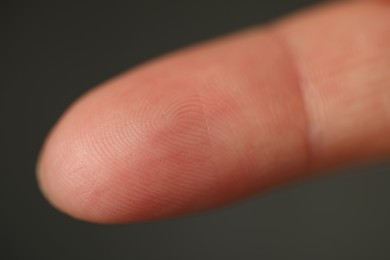 Photo of Closeup view of human finger on dark background