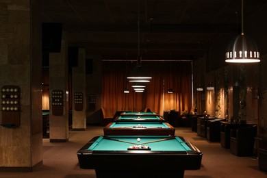Photo of Billiard tables with balls and cues in club