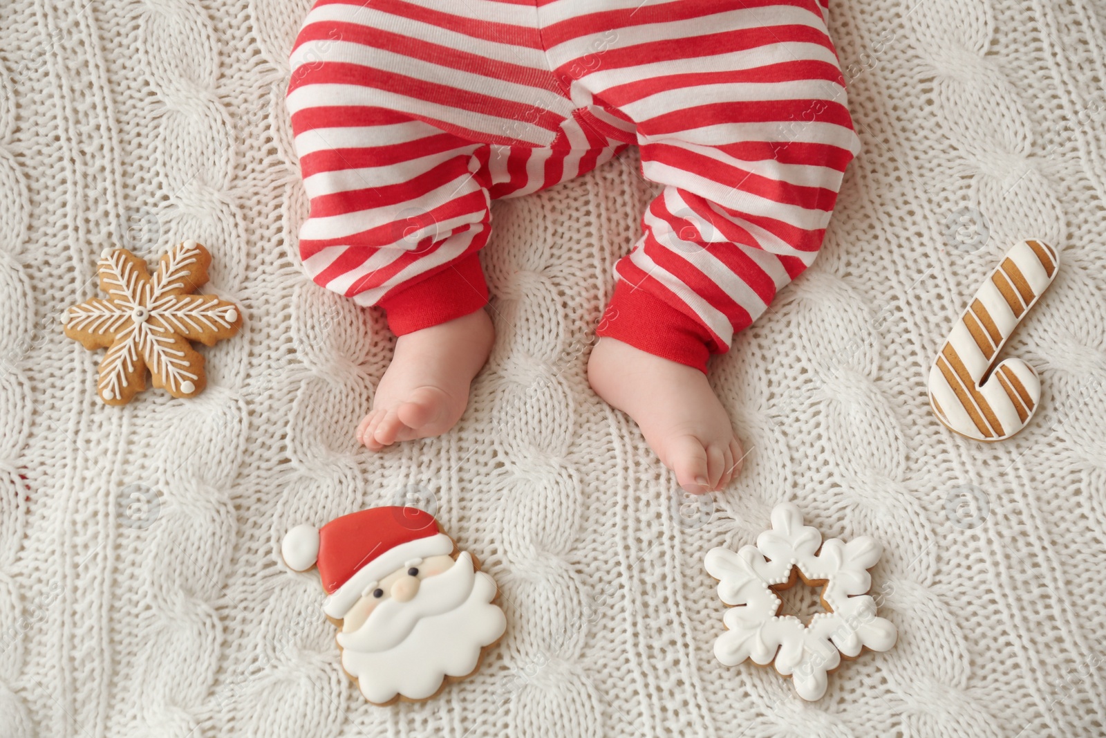 Photo of Cute little baby and Christmas cookies on blanket, top view