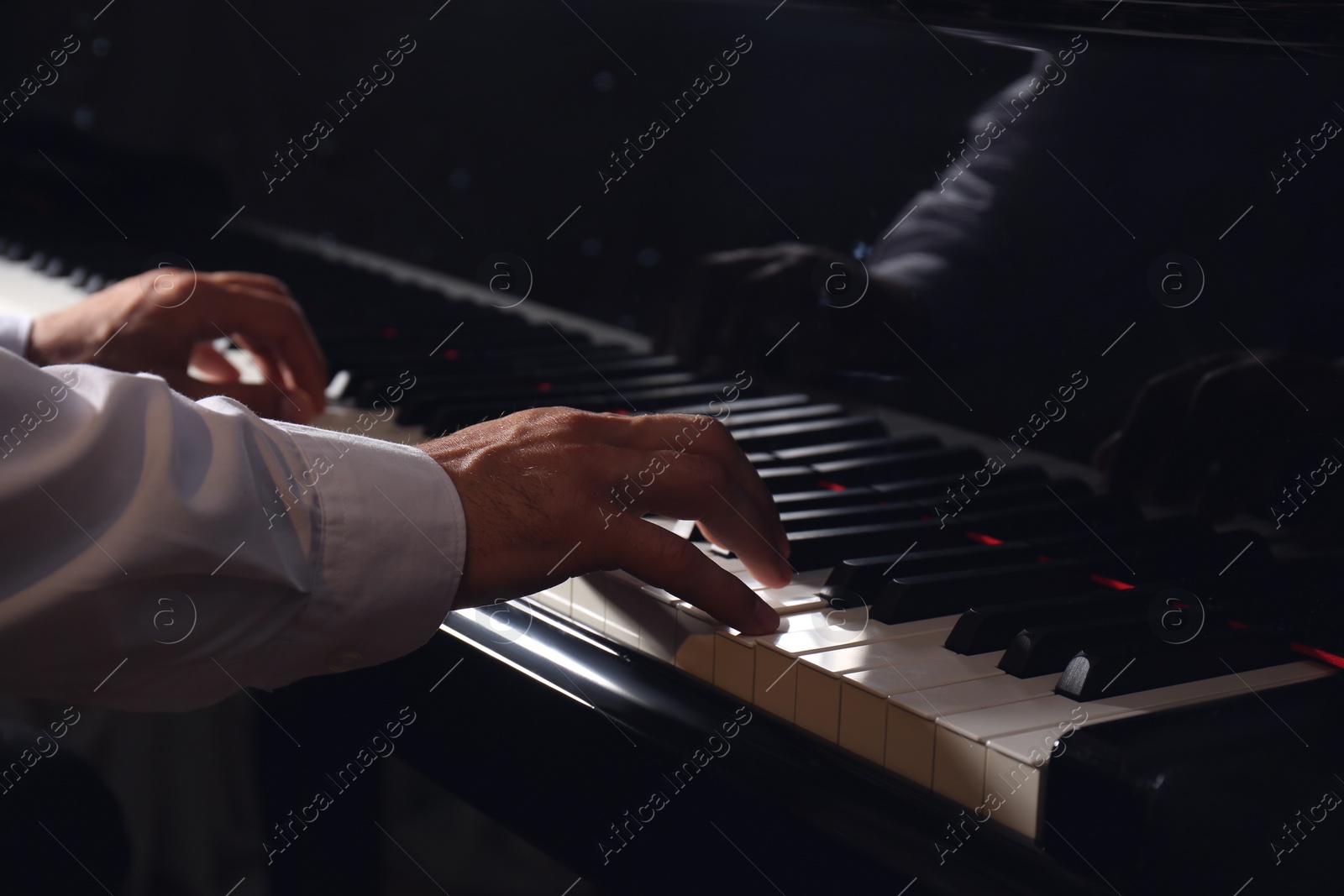 Photo of Man playing grand piano, closeup. Talented musician