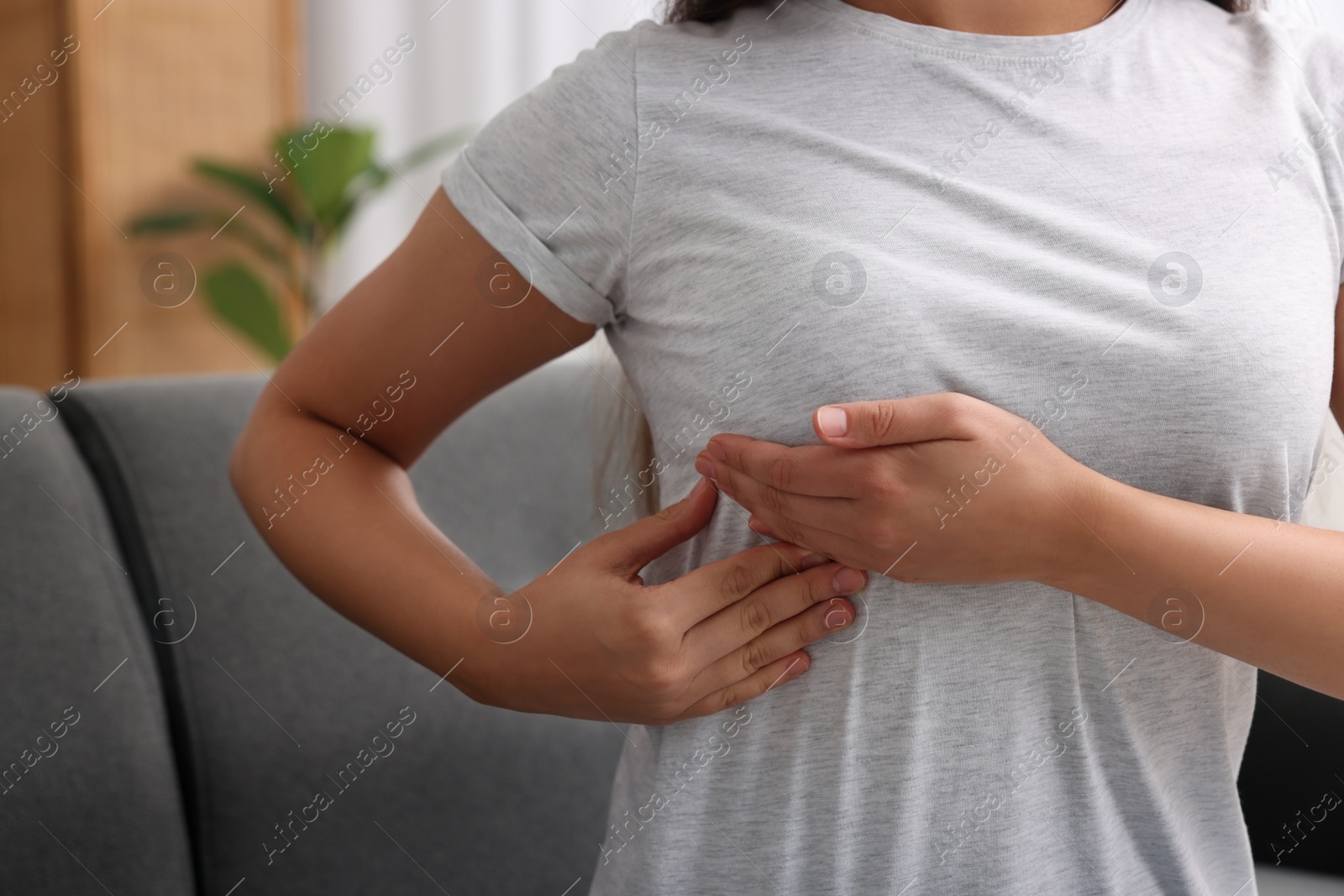 Photo of Woman doing breast self-examination at home, closeup