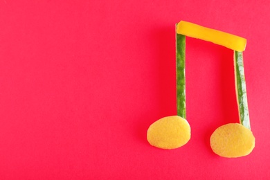 Photo of Musical note made of vegetables and fruits on color background, top view. Space for text