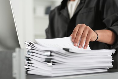 Man working with documents at grey table in office, closeup