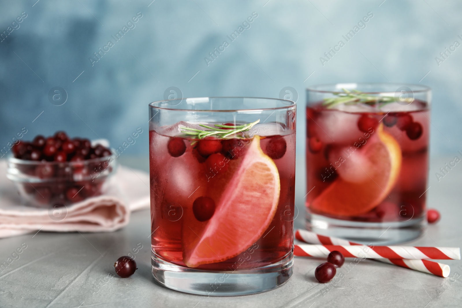 Photo of Tasty refreshing cranberry cocktail on light grey table