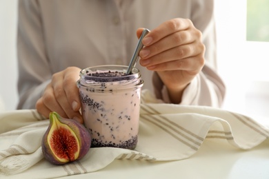 Photo of Woman with delicious fig smoothie at white table indoors, closeup