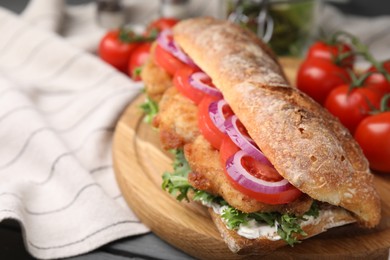 Delicious sandwich with schnitzel on grey wooden table, closeup. Space for text