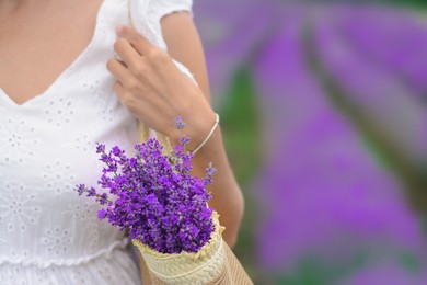 Photo of Woman with bag of beautiful lavender flowers in field, closeup