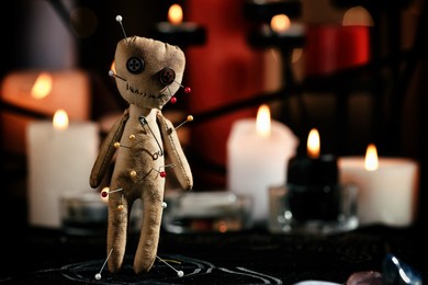 Photo of Voodoo doll pierced with pins on table in dark room, space for text. Curse ceremony