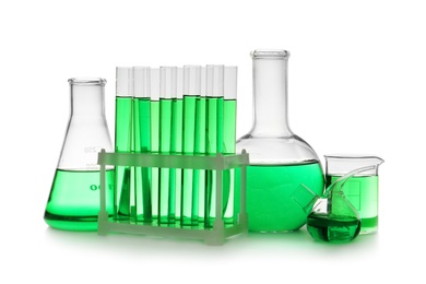 Laboratory glassware with green liquid on white background