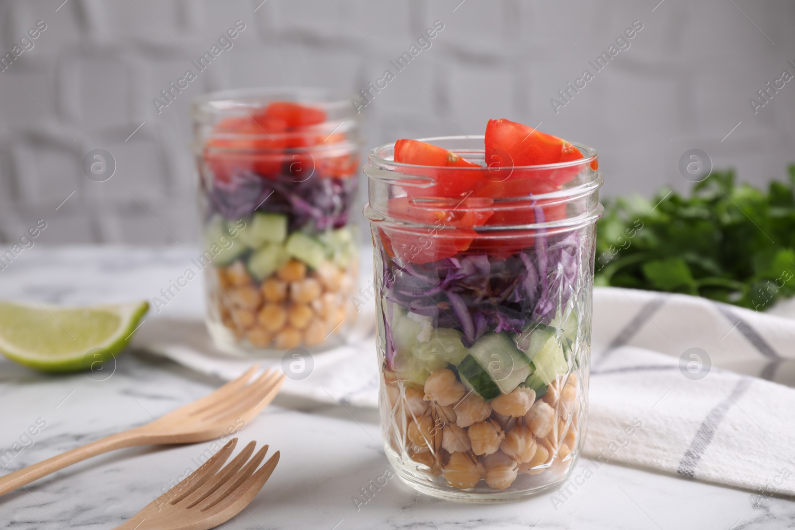 Photo of Healthy salad in glass jars on marble table