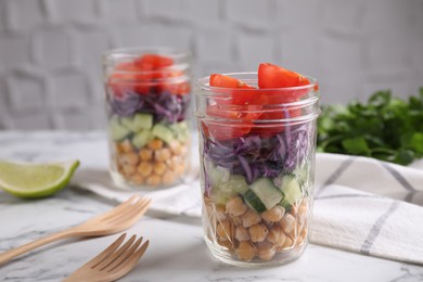 Photo of Healthy salad in glass jars on marble table