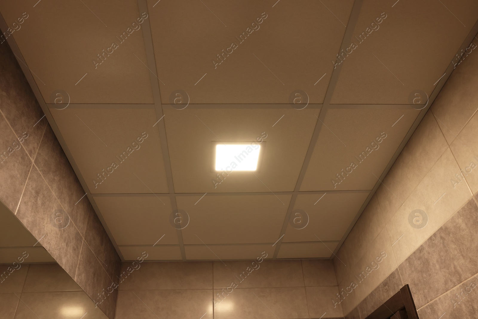 Photo of Ceiling with PVC tiles and lighting indoors, low angle view