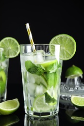 Photo of Delicious mojito and ingredients on black background