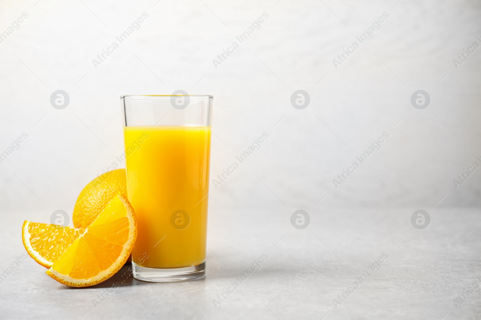 Photo of Freshly made orange juice on light table. Space for text