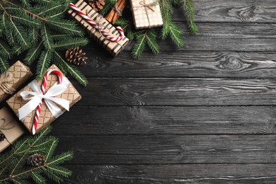 Flat lay composition with Christmas gift boxes and fir branches on wooden background