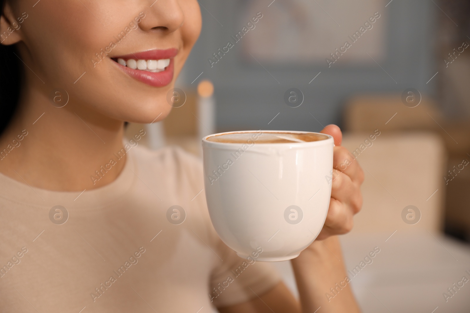 Photo of Woman enjoying delicious coffee at cafe in morning, closeup