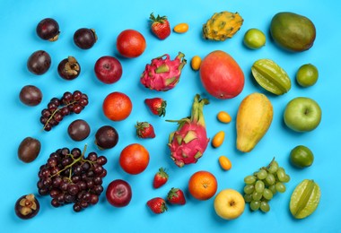 Photo of Assortment of fresh exotic fruits on light blue background, flat lay