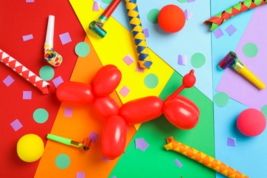 Photo of Clown's accessories and dog figure made of modelling balloon on color background