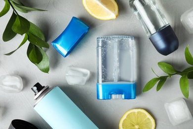 Flat lay composition with different natural deodorants on grey table